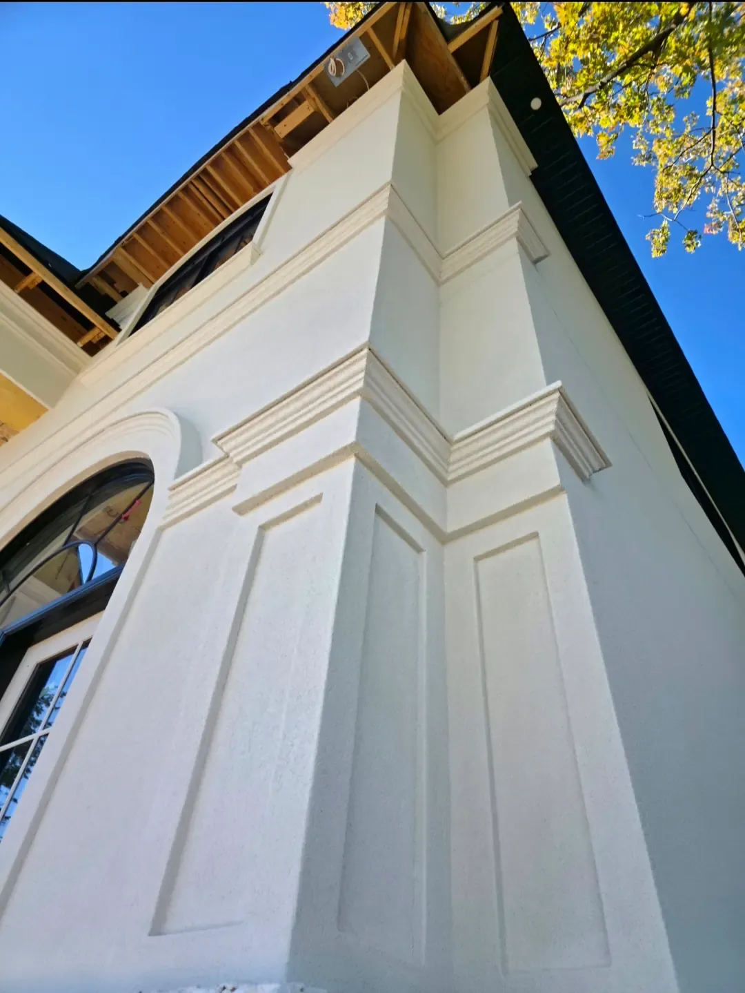 Stucco pilaster, arched window surround and cornice detail