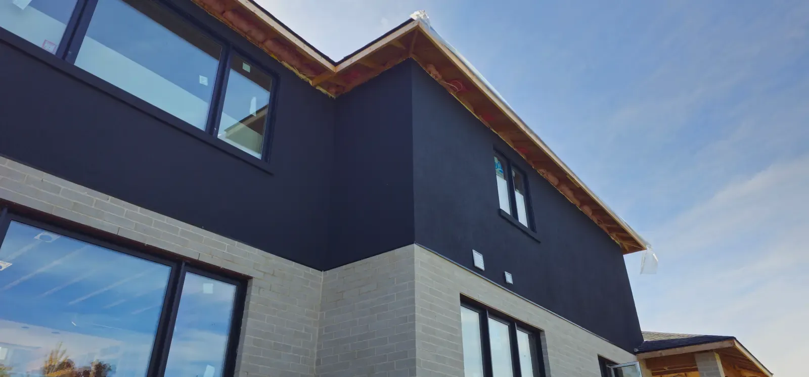 Two-tone modern home in St. Catharines with dark upper stucco and light base